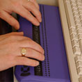 Braille keyboard with hands typing, © RNIB www.rnib.org.uk/technology